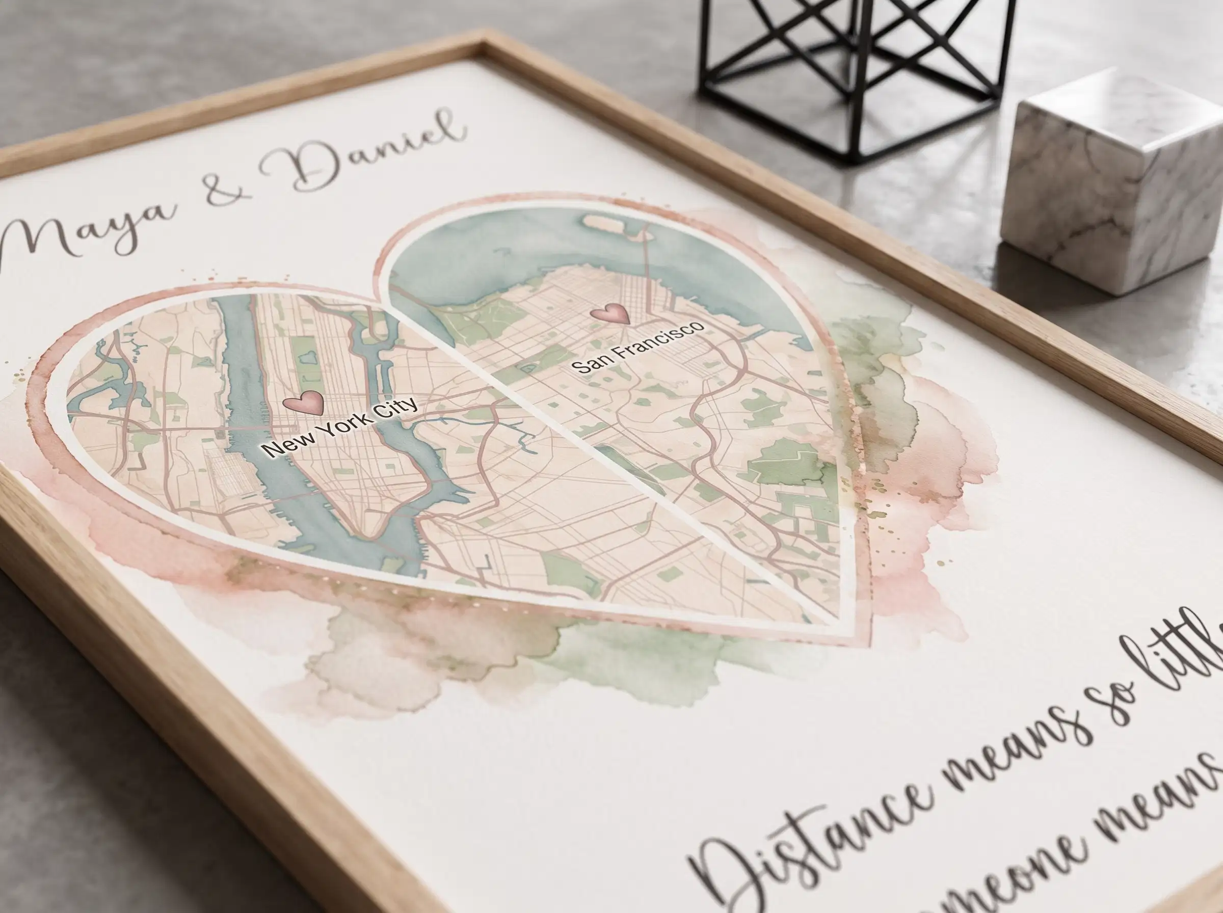 Framed miles apart map art resting on a contemporary work from home desk beside a laptop and ceramic mug